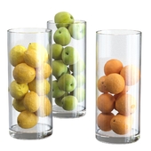 Lemons, oranges and apples in tall vases